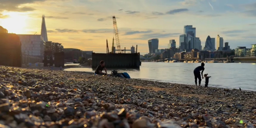 Handheld Smartphone Recording Video Along An Urban Riverbank During Sunset